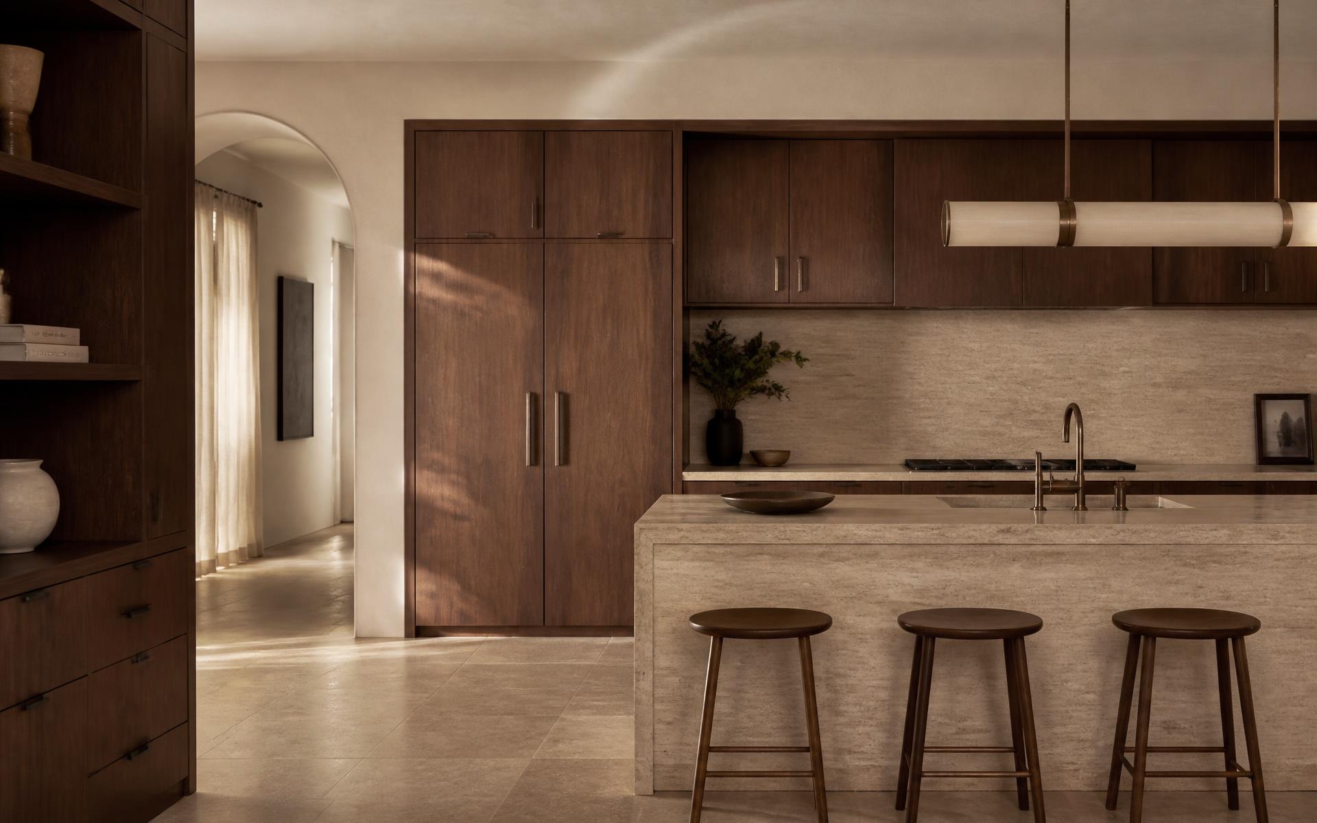 Bespoke kitchen with walnut cabinetry and a honed travertine island in soft daylight